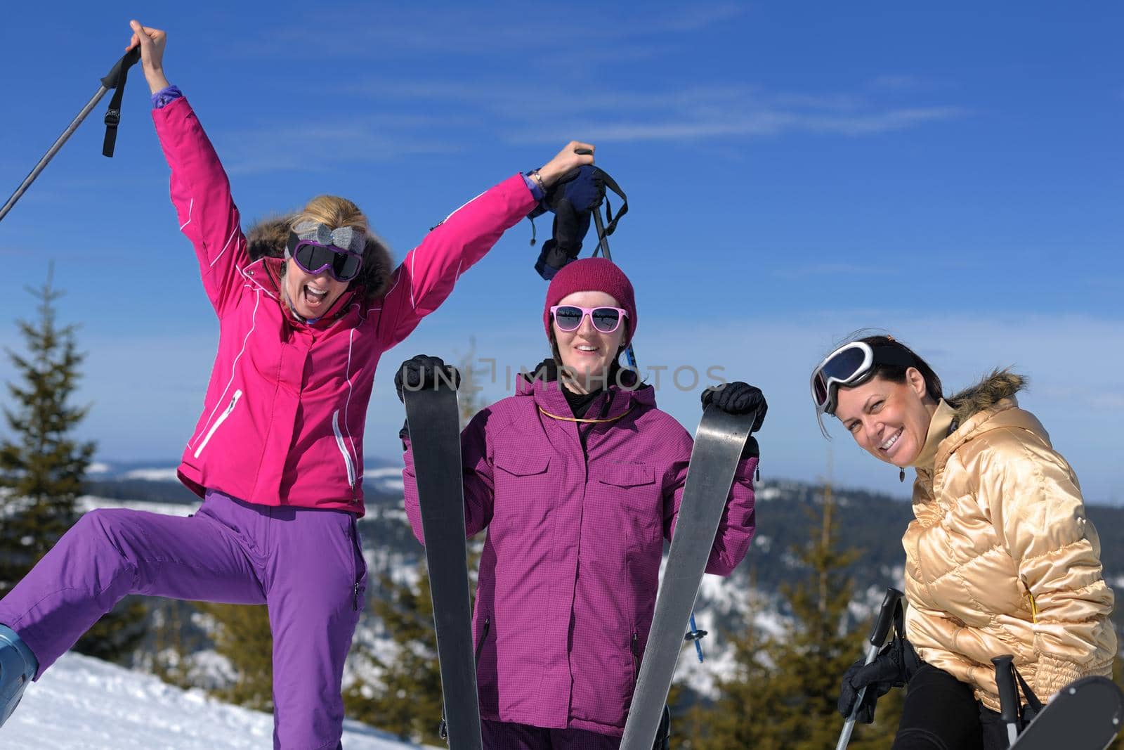 happy friends group of woman girls have fun at winter season at beautiful sunny  snow day with blue sky in background