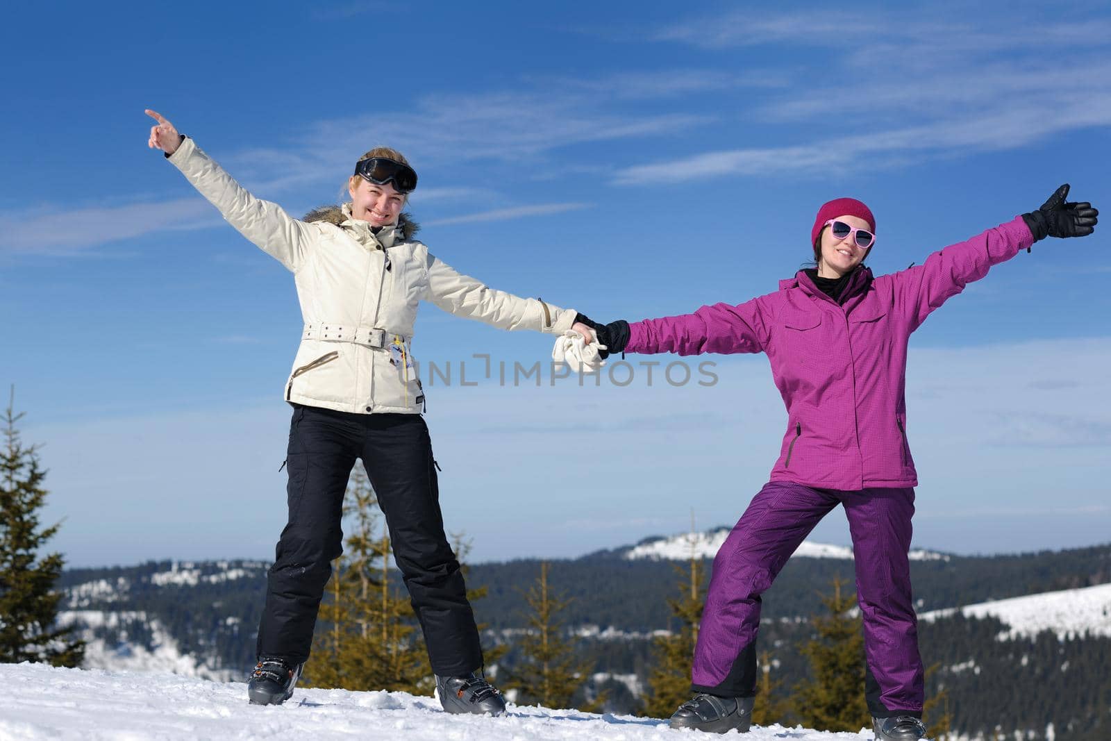 happy friends group of woman girls have fun at winter season at beautiful sunny  snow day with blue sky in background