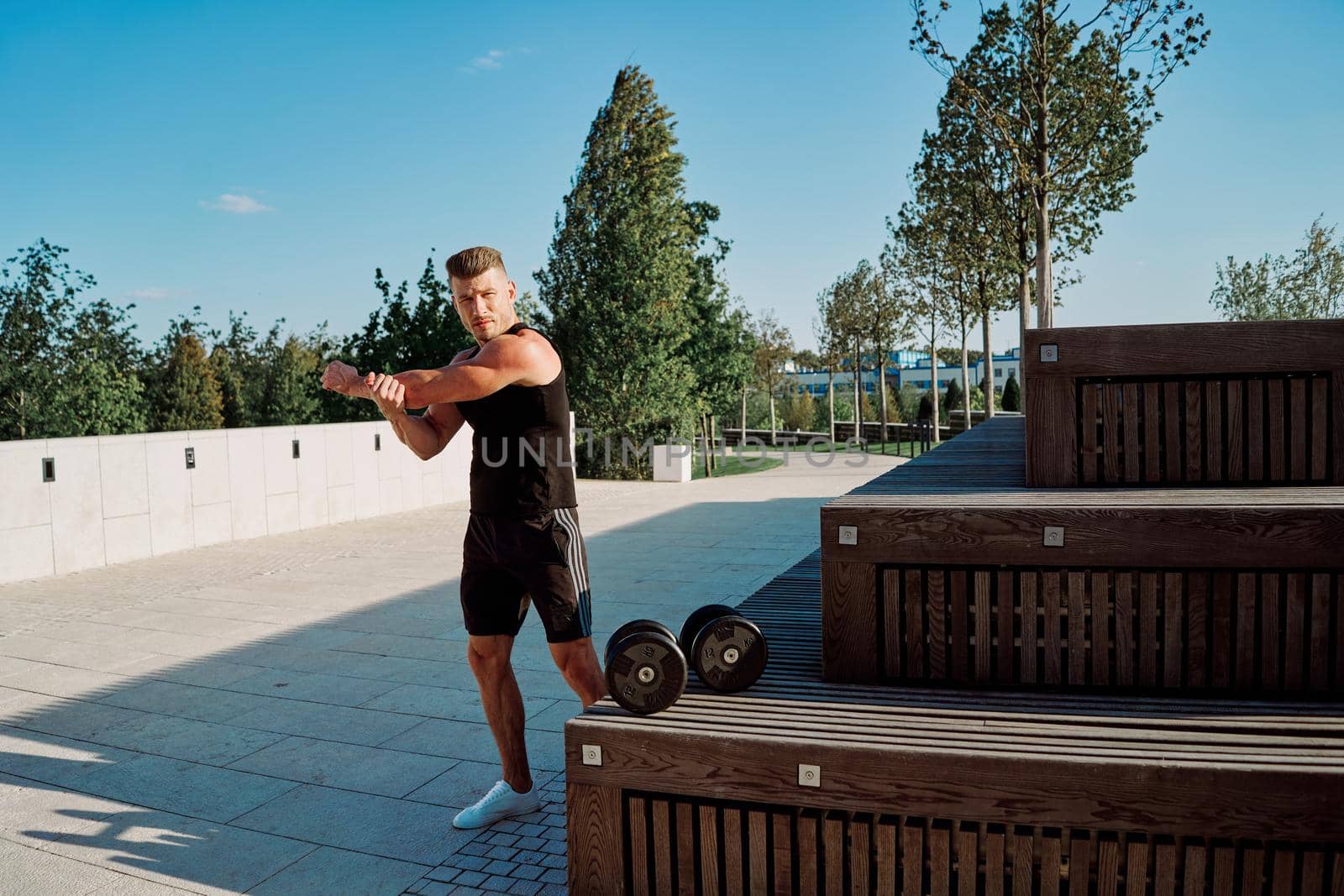 sporty man in the park with dumbbells workout fitness. High quality photo