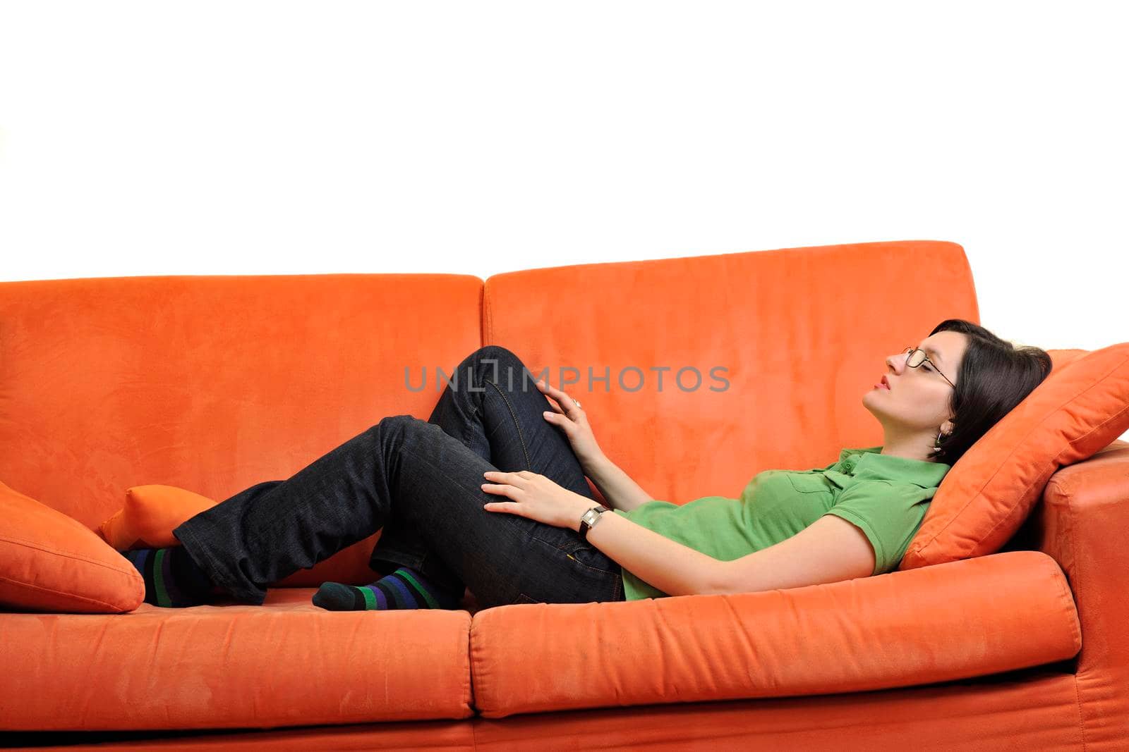 happy young woman relax on orange sofa  at home isolated on white background in studio