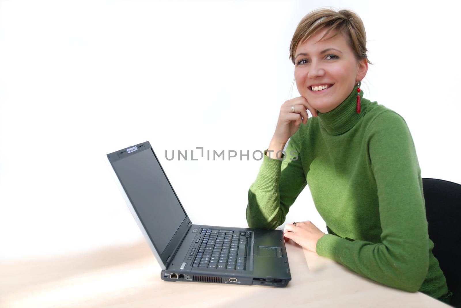 businesswoman in green working on laptop