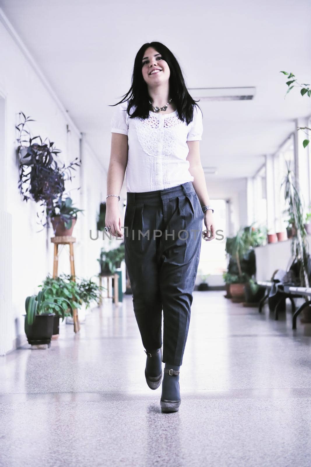young happy business woman or student posing in fashionable clothes indoor in bright building 
