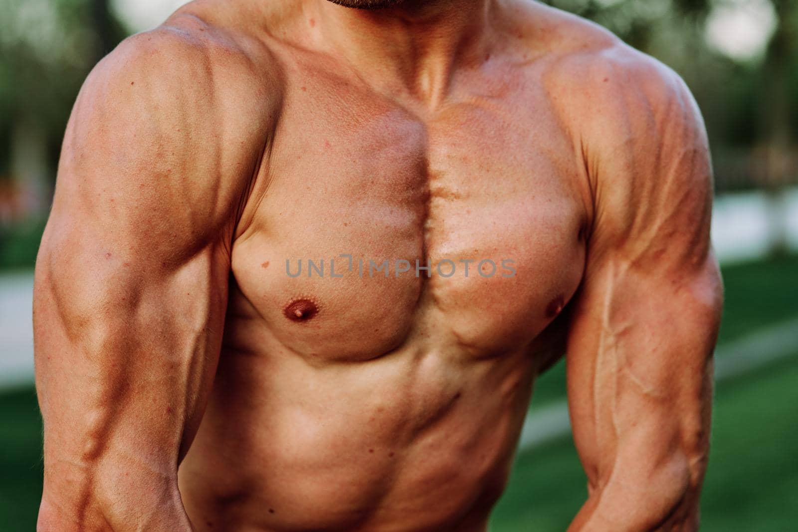 man with pumped up muscular body outdoors health workout. High quality photo