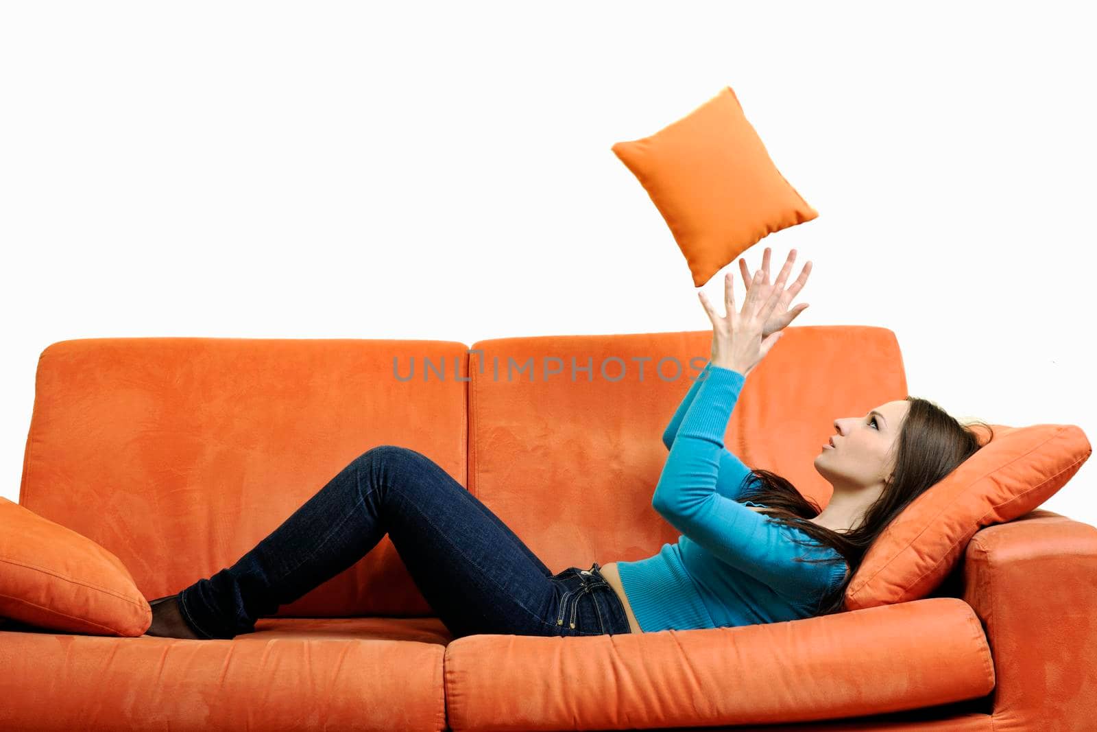 happy young woman relax on orange sofa isolated on white in studio