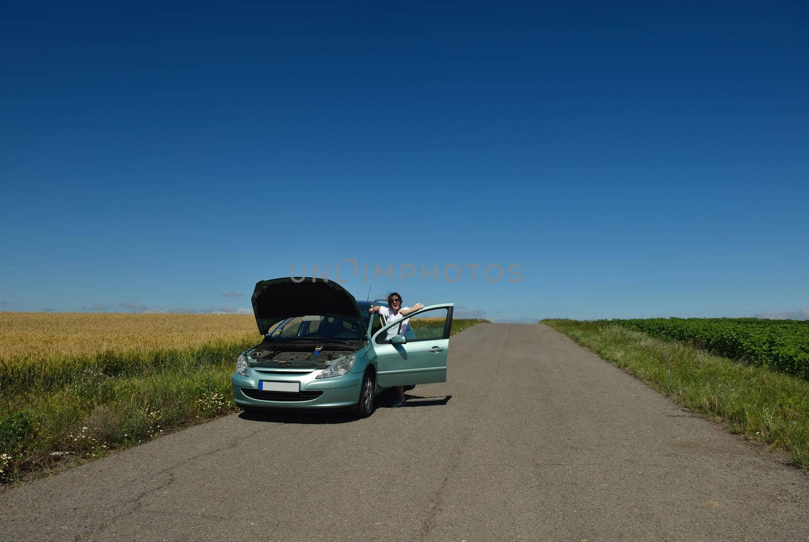 portrait of young beautiful woman with broken car outdoor