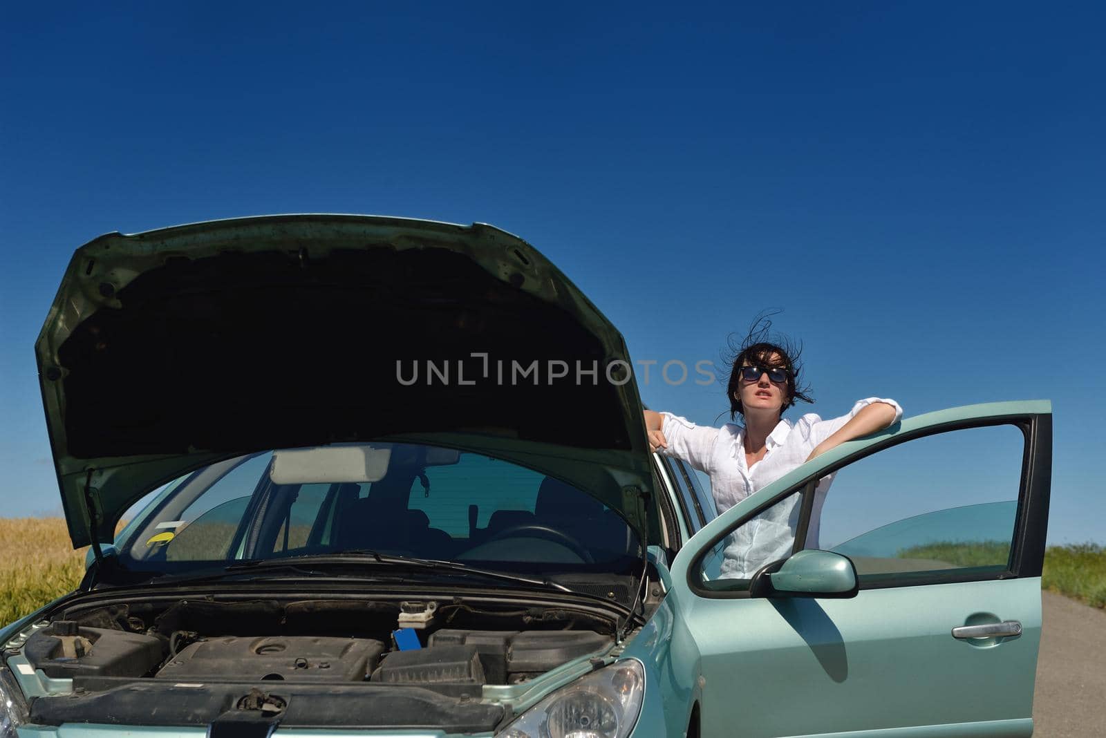 portrait of young beautiful woman with broken car outdoor