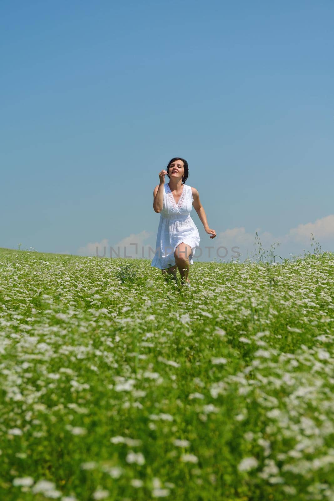 Young happy woman in green field by dotshock