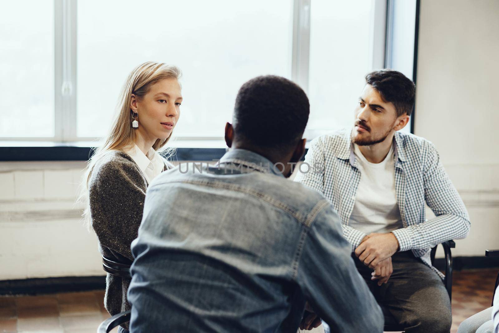 Young people sitting in a circle and having a group discussion