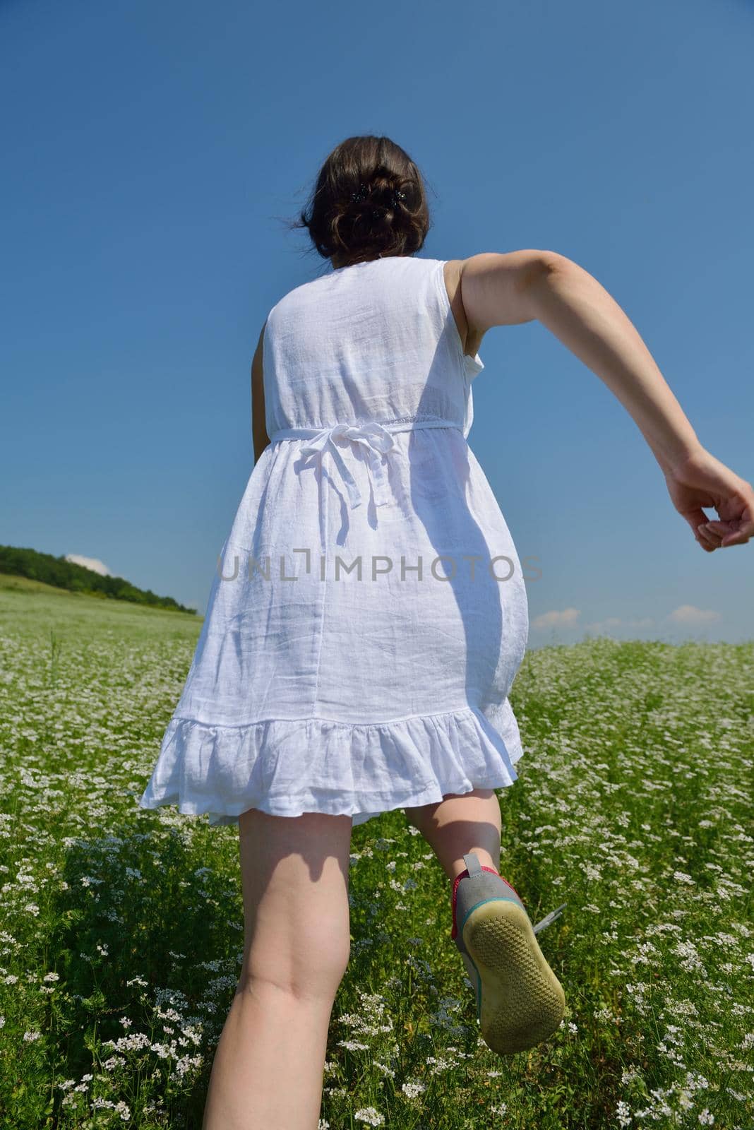 Young happy woman in green field by dotshock