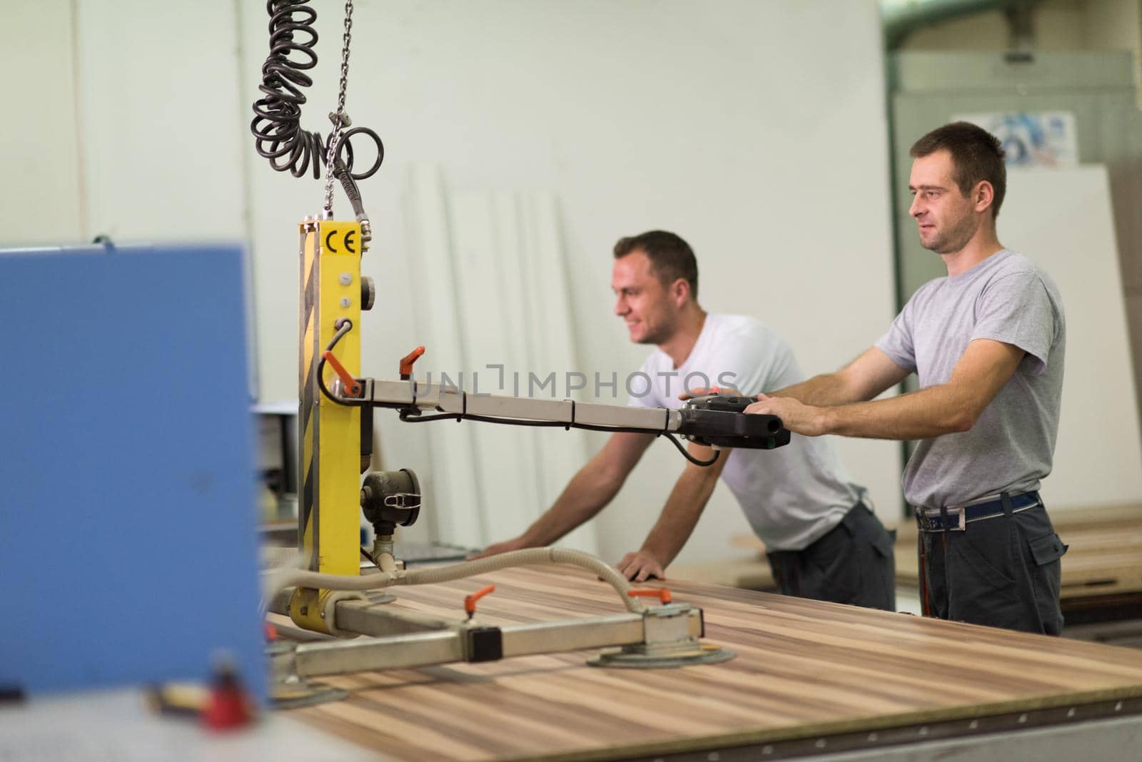 workers in a factory of wooden furniture by dotshock