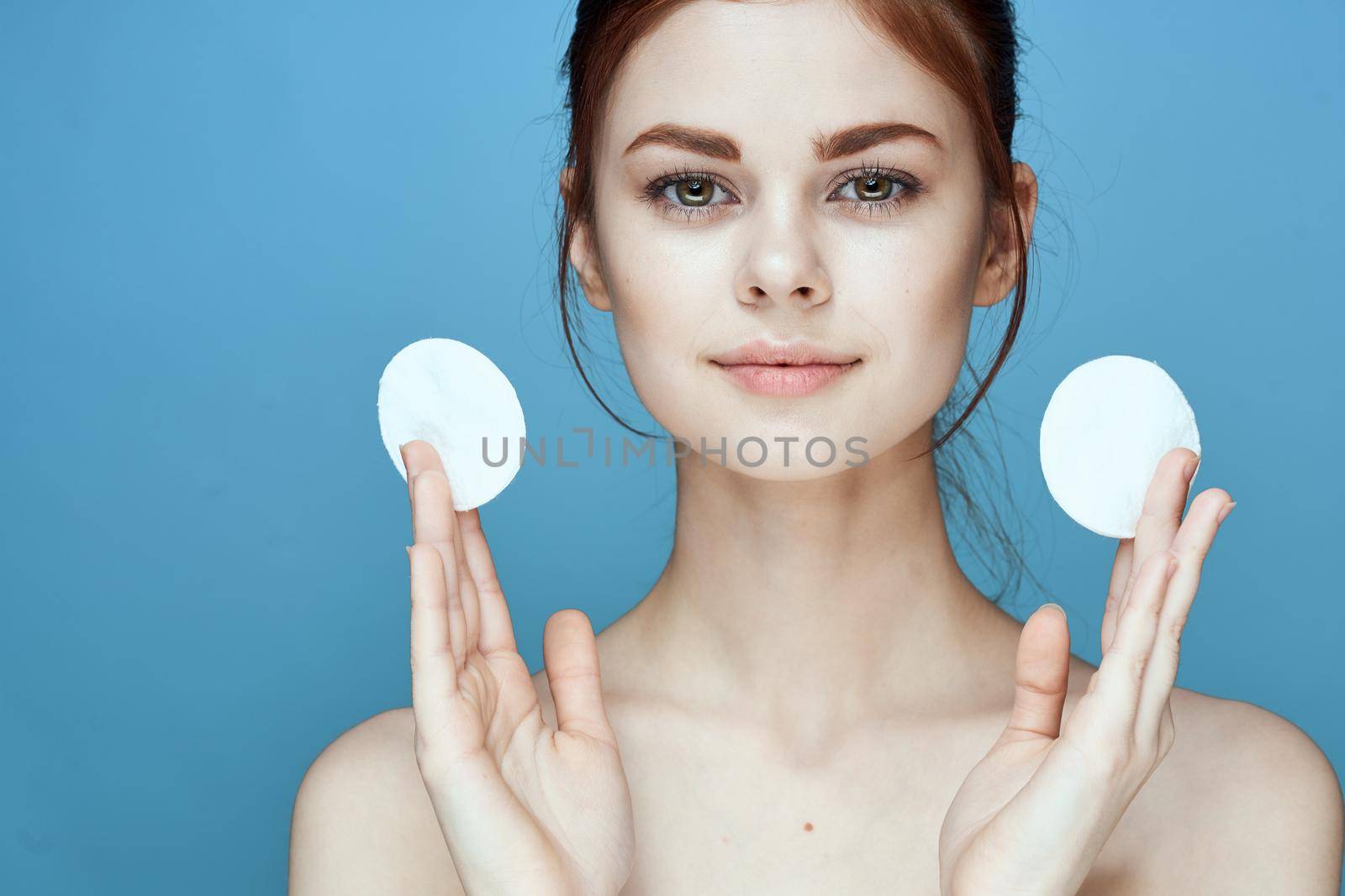 woman with bare shoulders cucumber vitamins health blue background. High quality photo