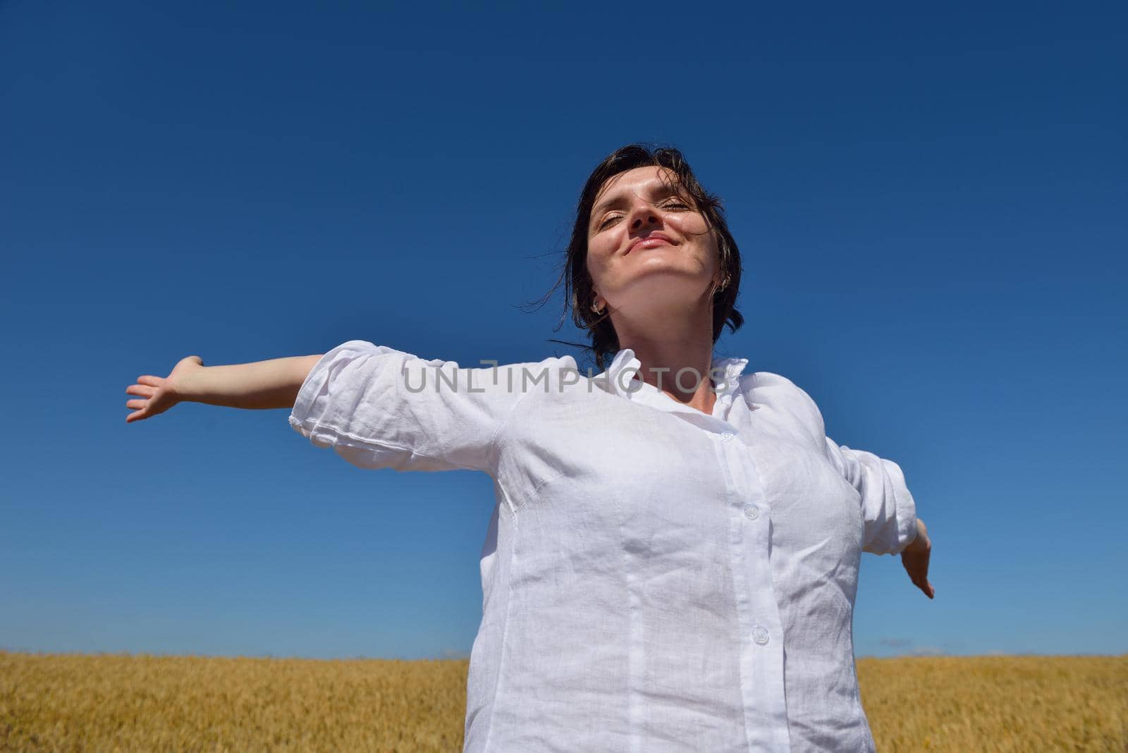 healthy Happy  young woman with spreading arms, blue sky with clouds in background  - copyspace