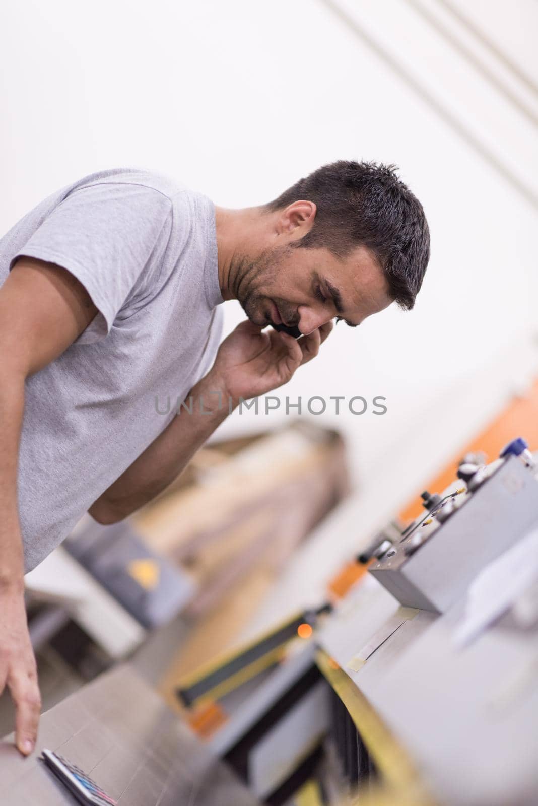 young positive engineer in front of furniture manufacture production at wood cutting machine