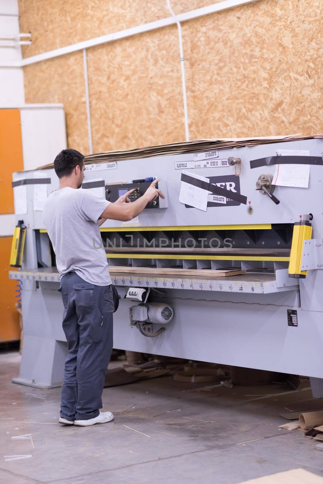 Young worker works in a factory for the production of wooden furniture