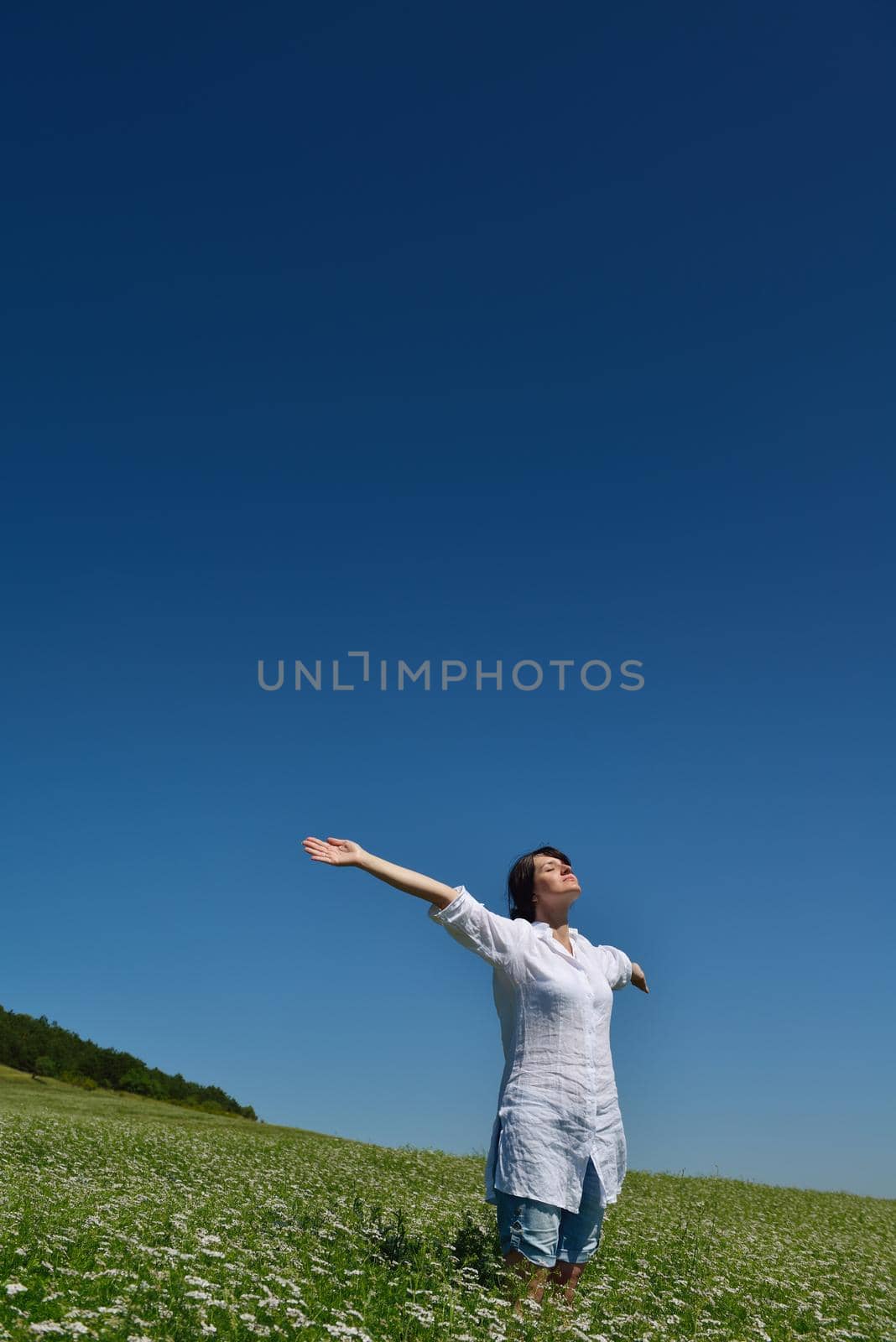 Young happy woman in green field by dotshock