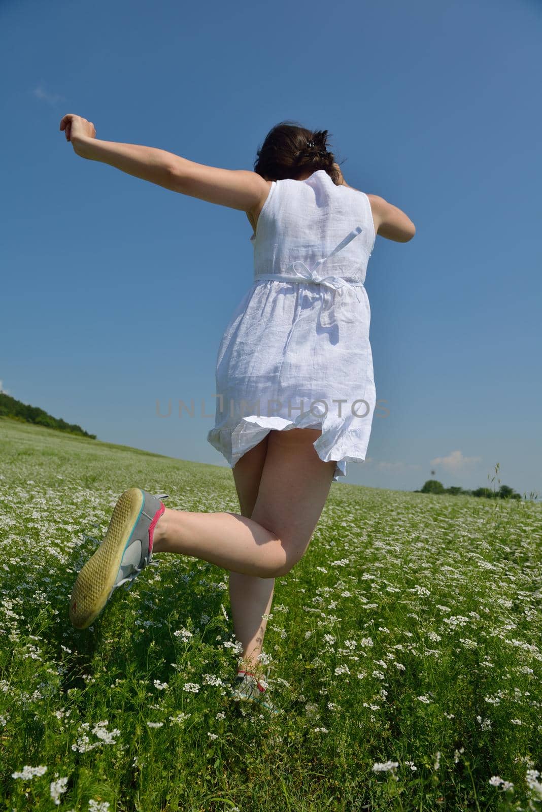 Young happy woman in green field by dotshock