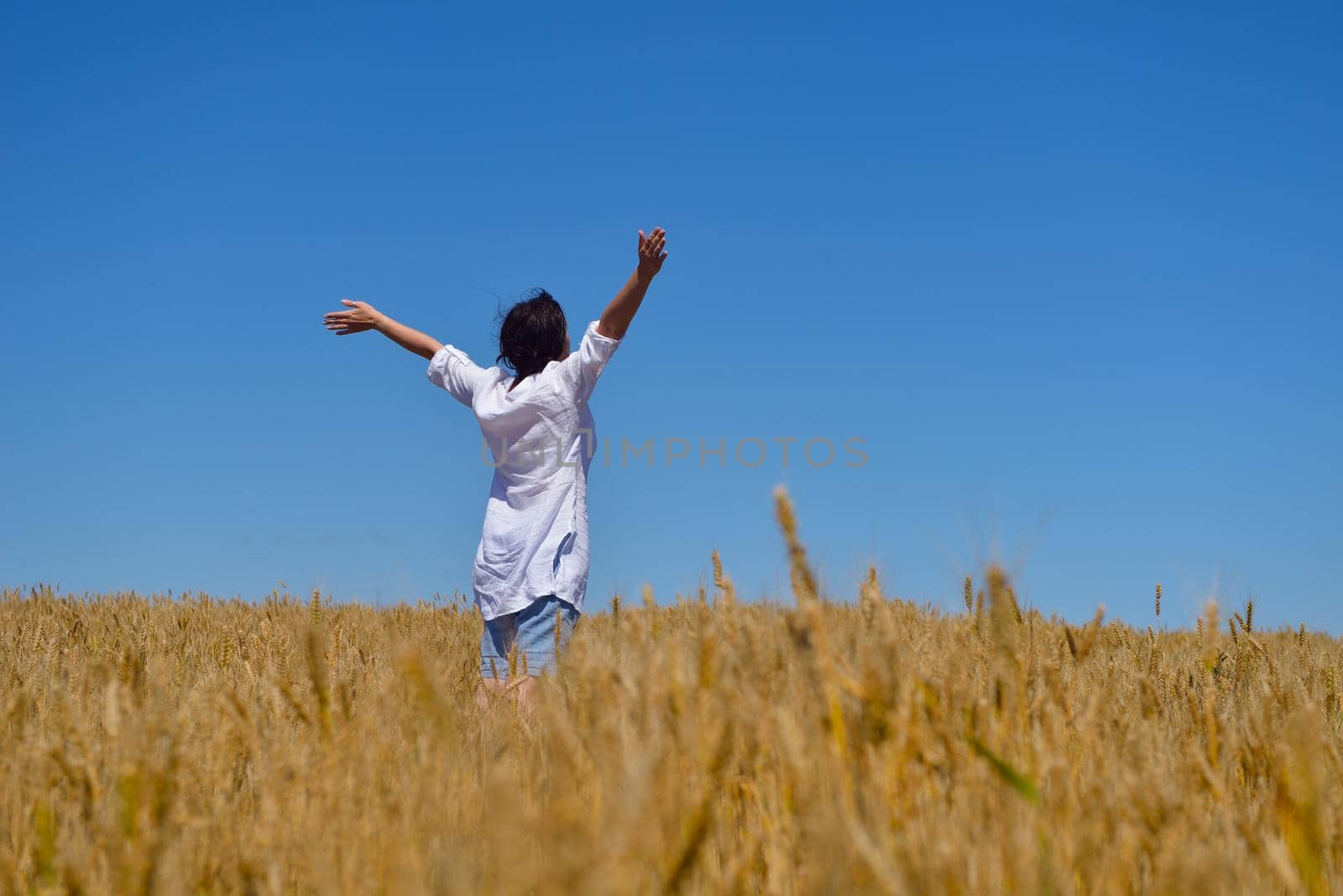 healthy Happy  young woman with spreading arms, blue sky with clouds in background  - copyspace