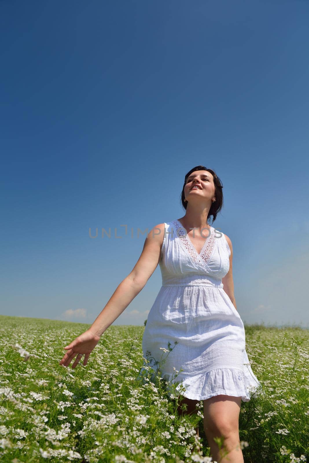 Young happy woman in green field by dotshock