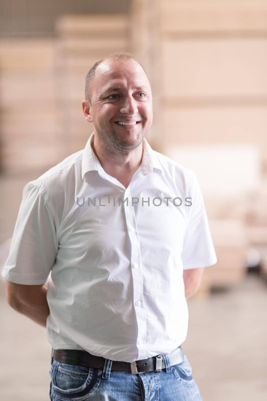 Portrait of an independent designer in his furniture manufacturing workshop, looking relaxed and confident