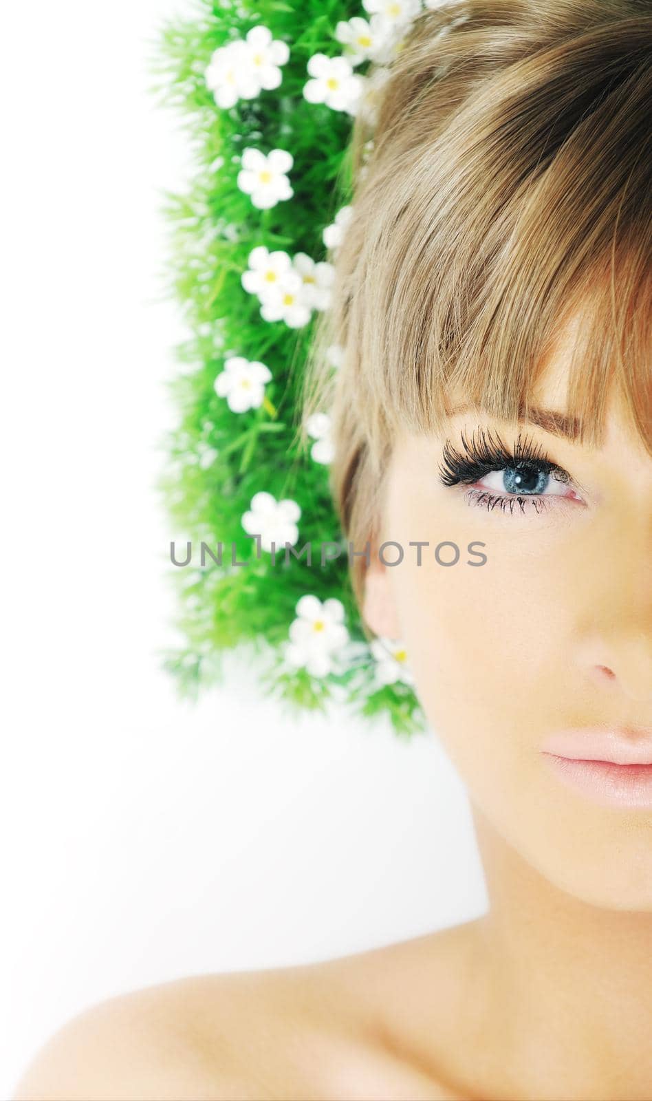 beautiful blonde woman face isolated on white with small green peace of grass