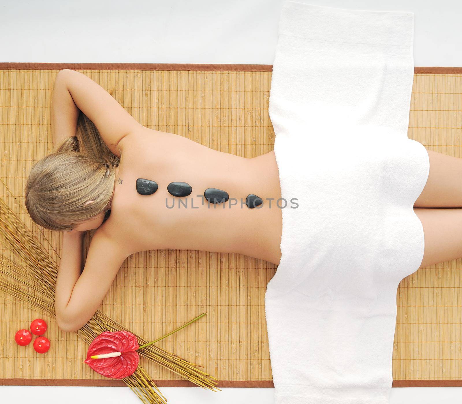 young healthy woman in wellness and spa studio have Massage with hot volcanic stones