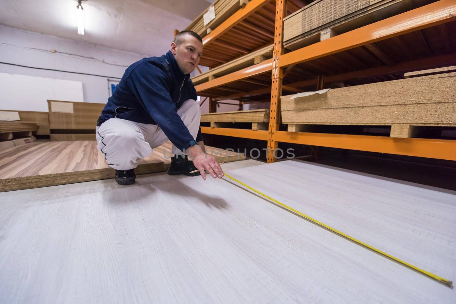 carpenter measuring wooden board by dotshock