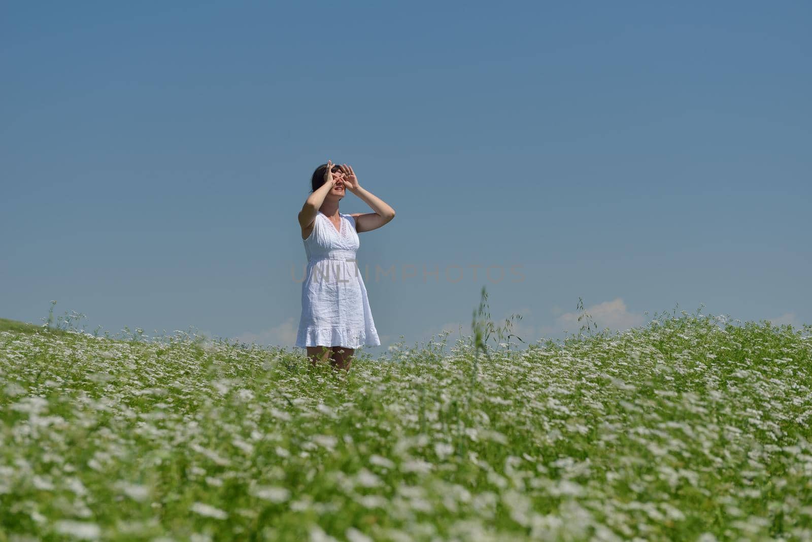 Young happy woman in green field by dotshock