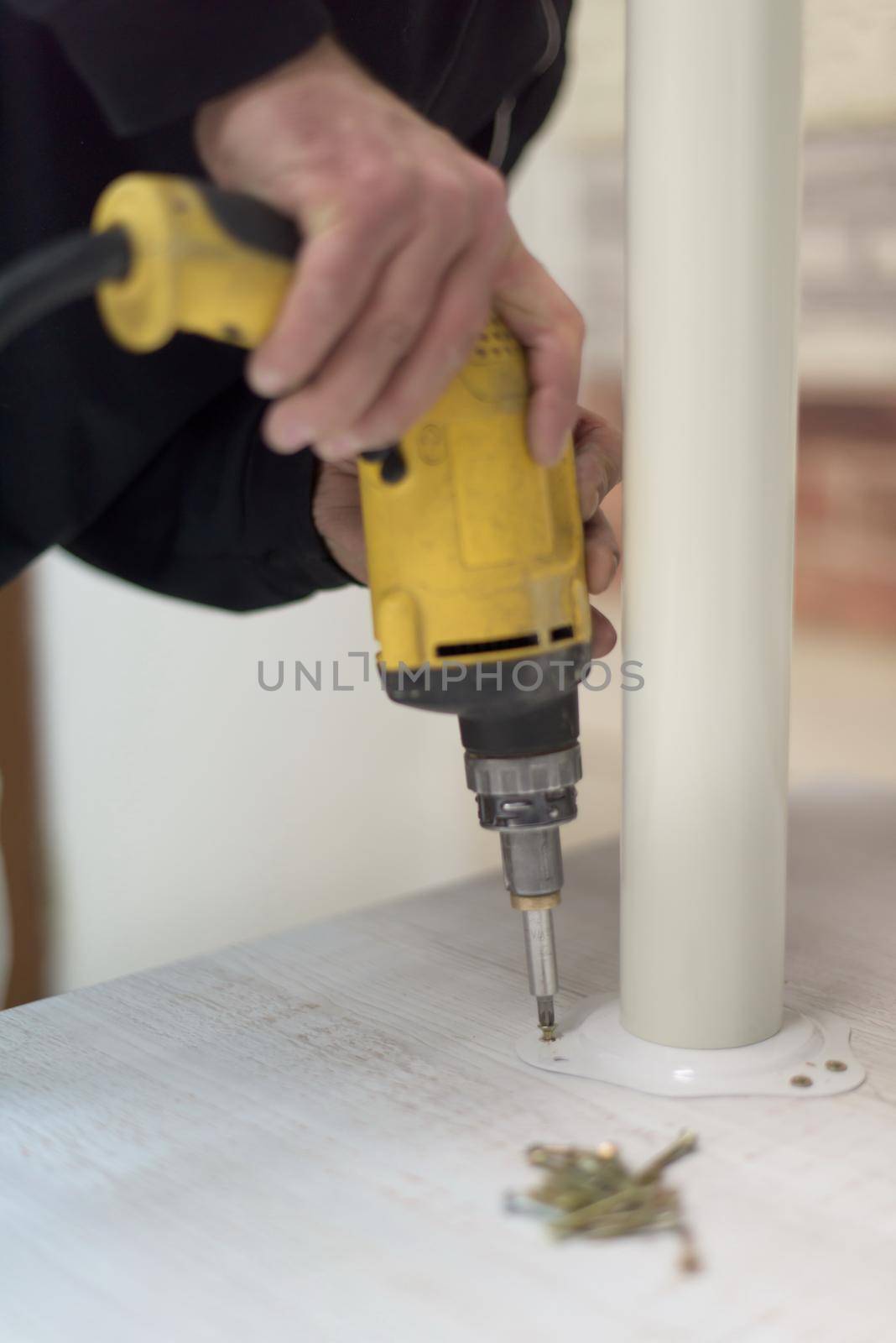 repairman working with drilling machine and assambling  furniture