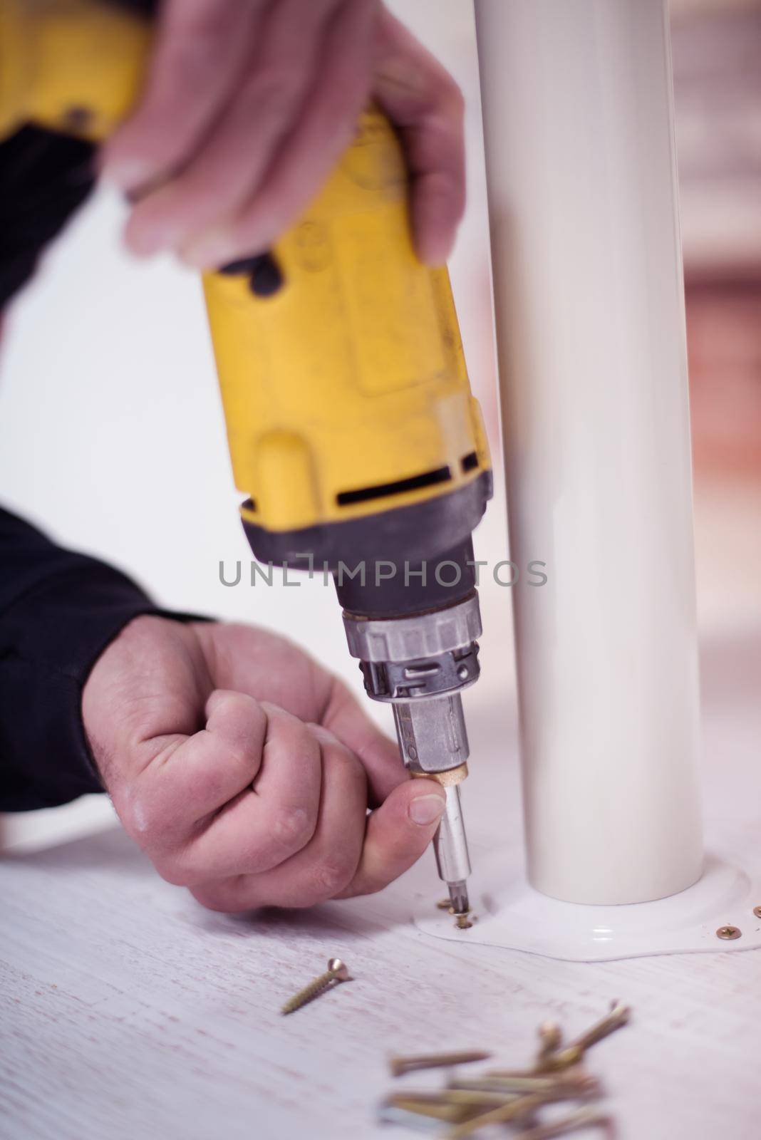 repairman working with drilling machine and assambling  furniture