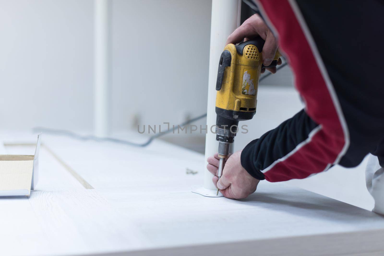 repairman working with drilling machine and assambling  furniture