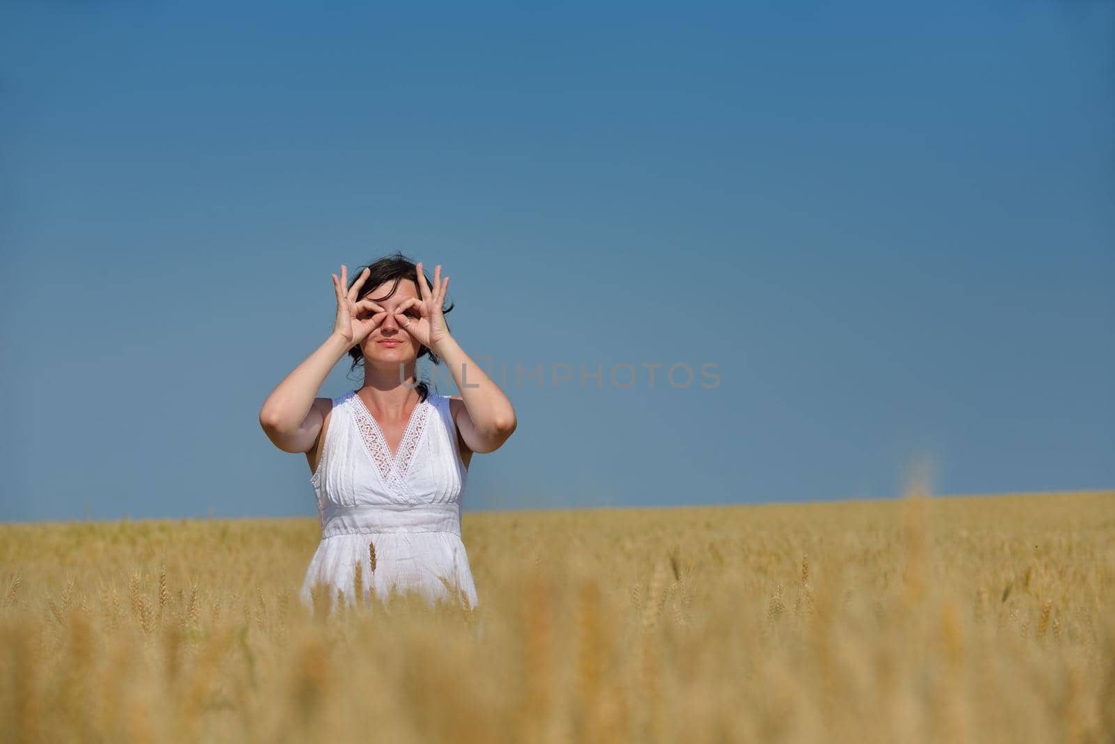 young woman in wheat field at summer by dotshock