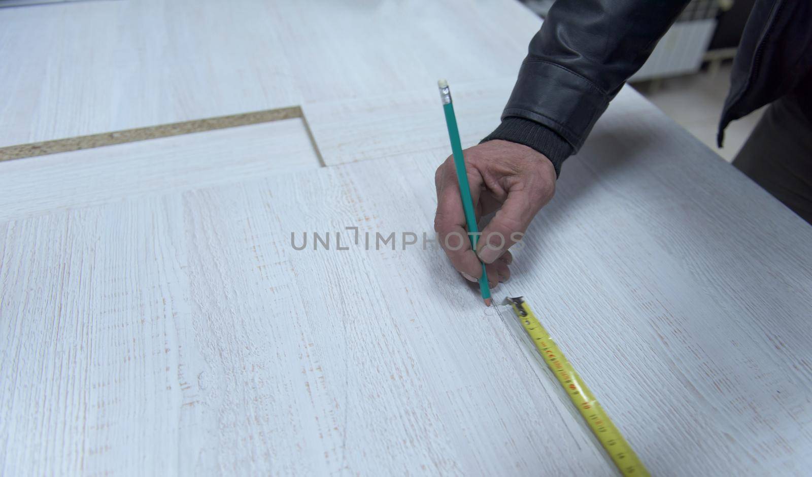 carpenter worker measuring distance for drilling holes in new furniture