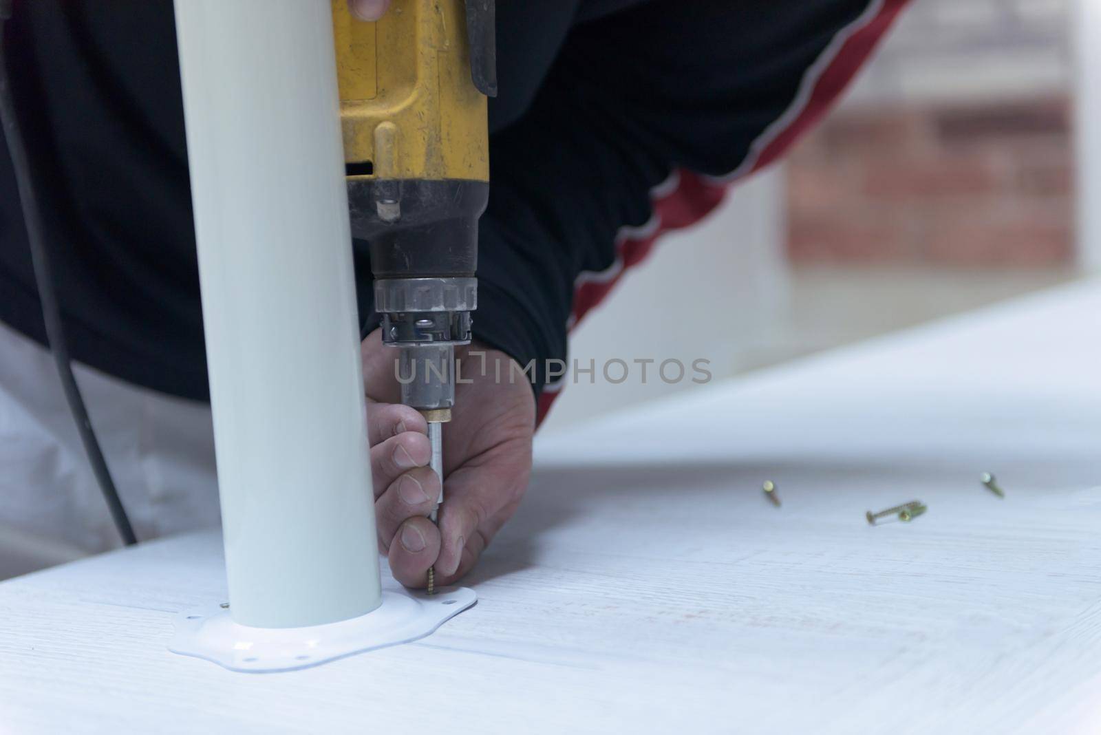 repairman working with drilling machine and assambling  furniture