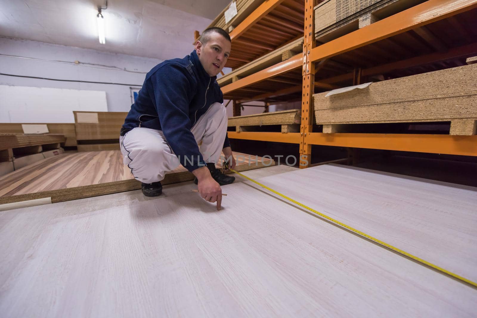 carpenter measuring wooden board by dotshock