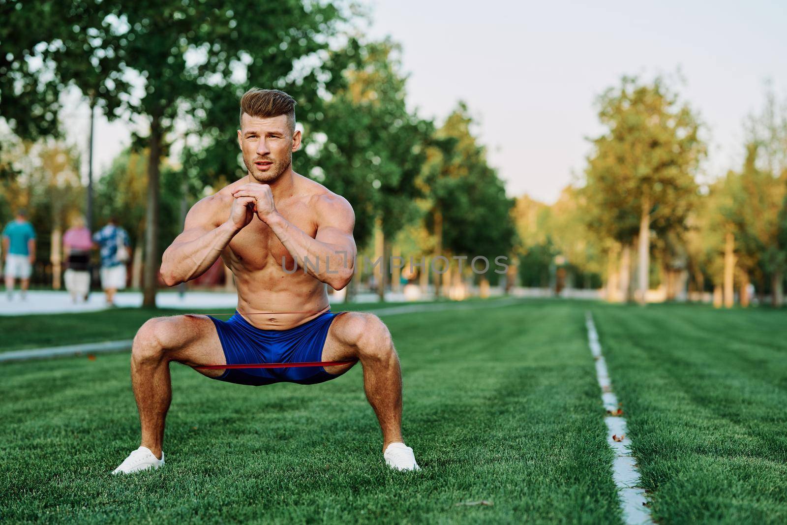 athletic man with a pumped up body in the park exercise fitness. High quality photo