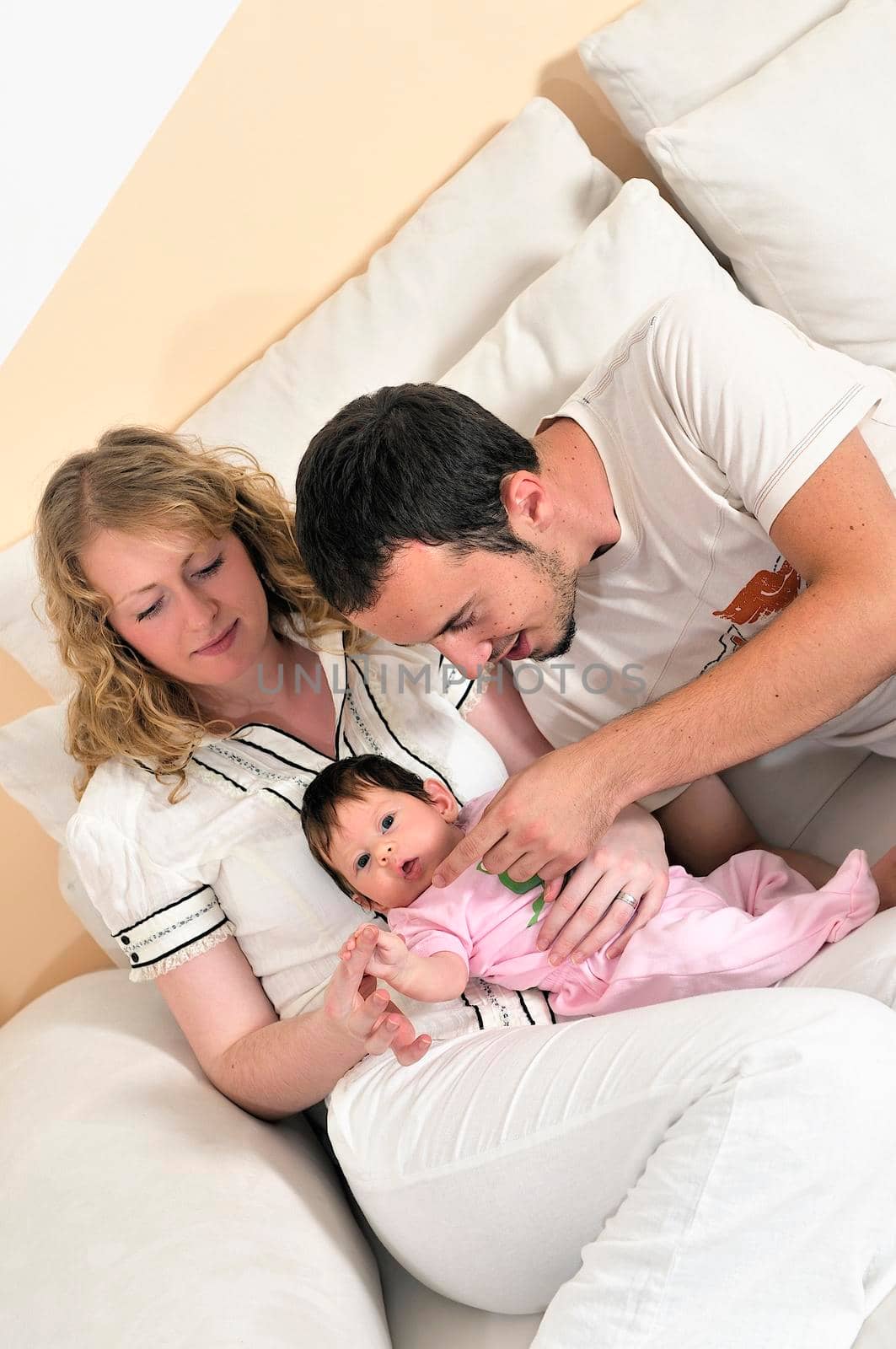 indoor portrait with happy young family and  cute little babby