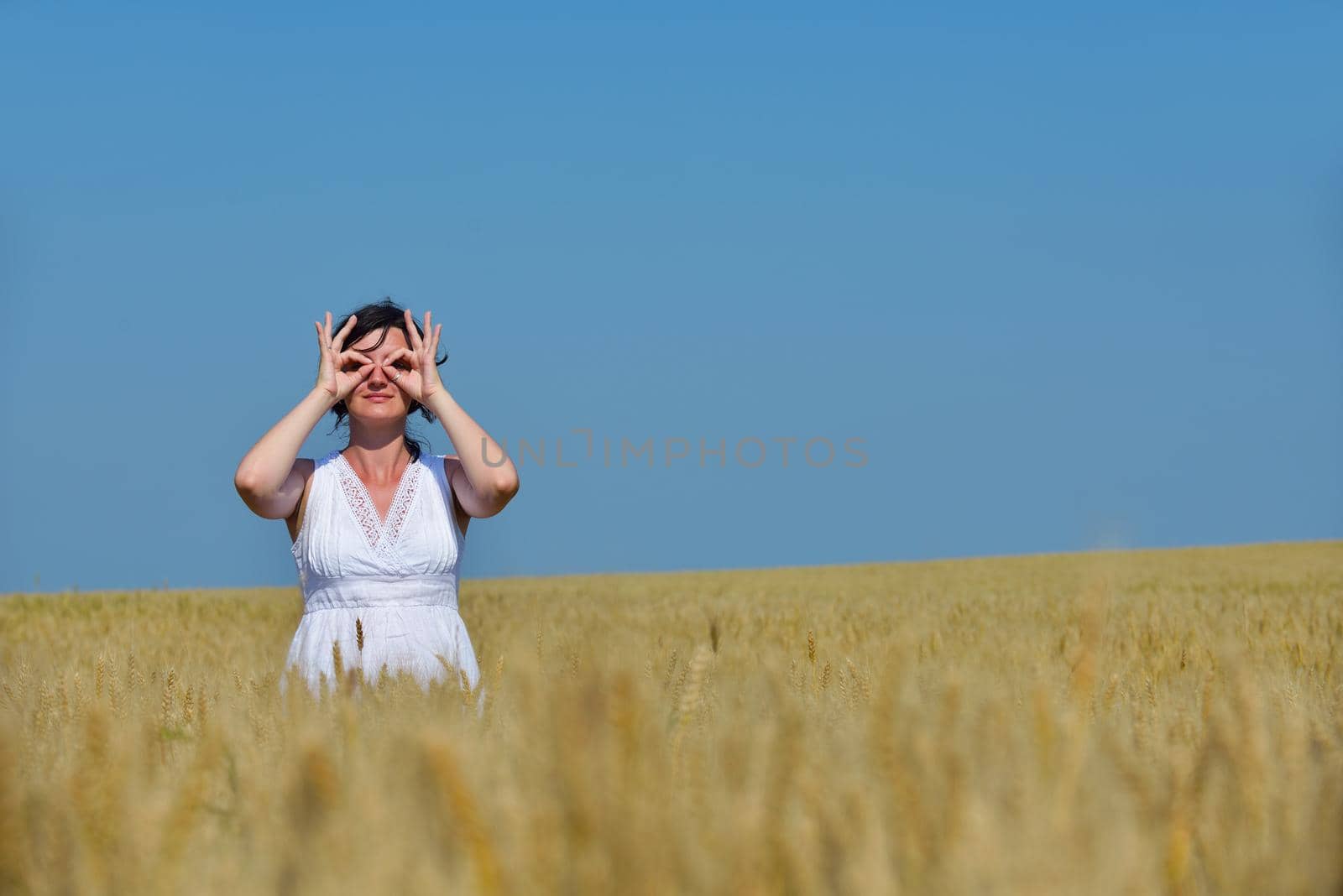 young woman in wheat field at summer by dotshock