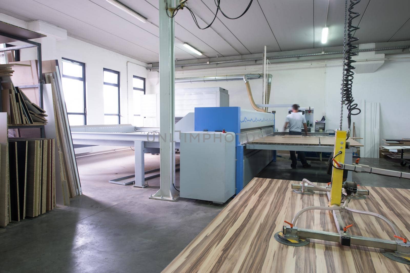 worker in a factory of wooden furniture by dotshock