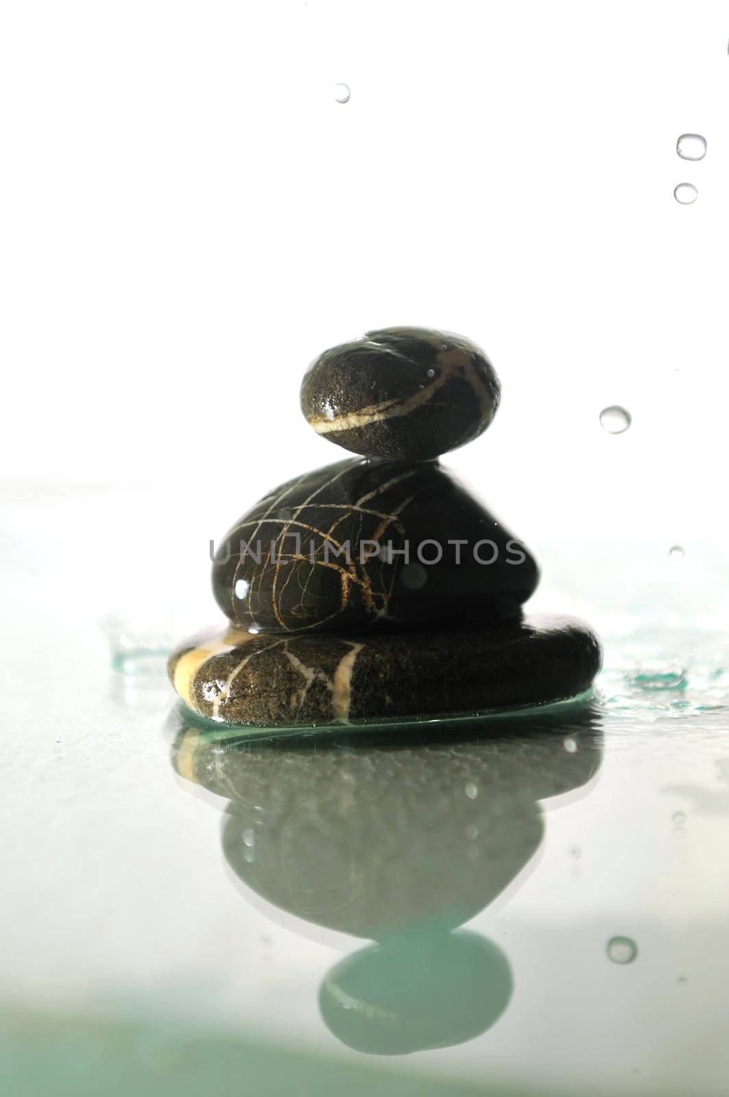 isolated wet zen stones with splashing  water drops by dotshock