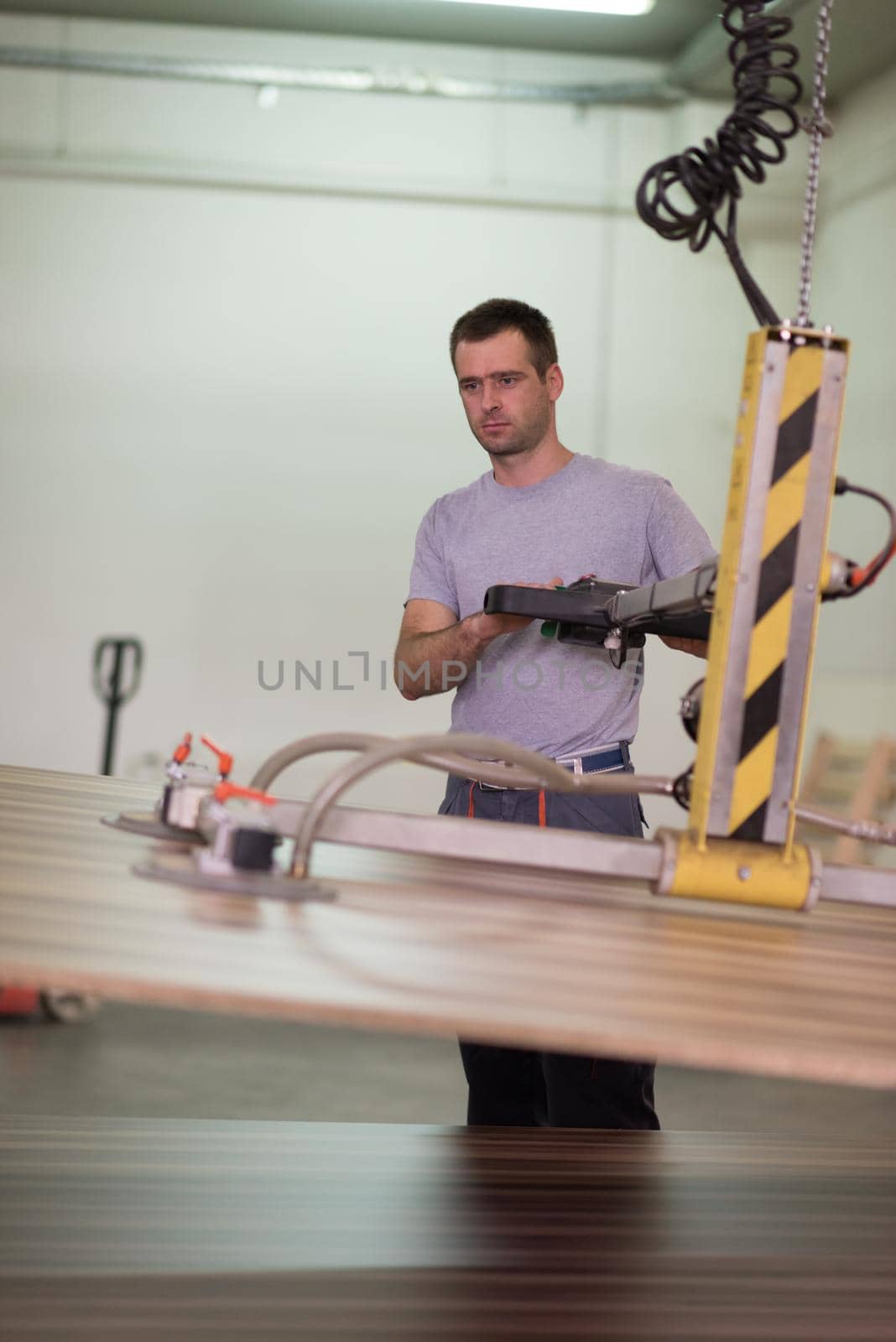 Young worker works in a factory for the production of wooden furniture