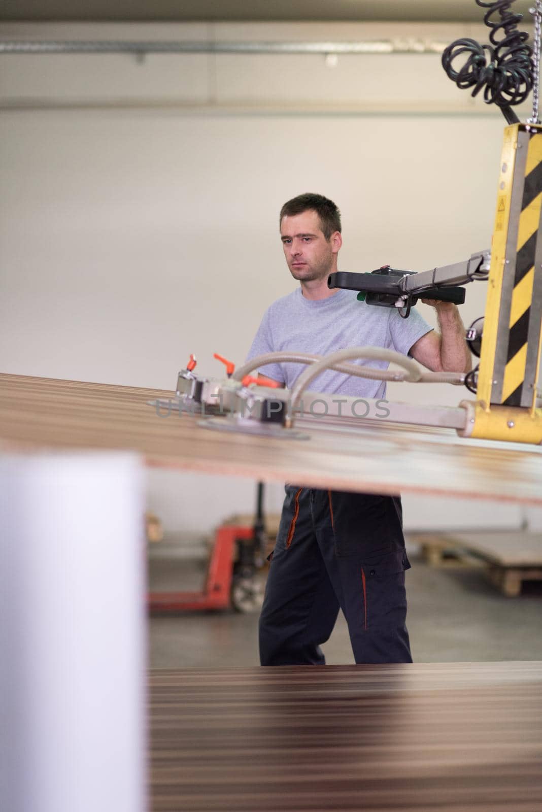 Young worker works in a factory for the production of wooden furniture