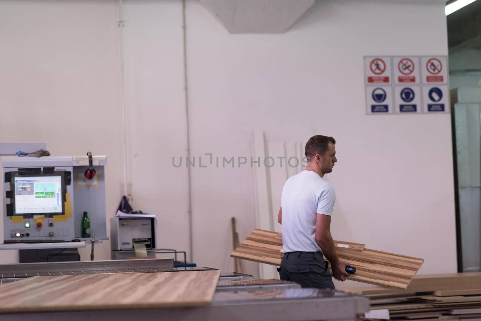 worker in a factory of wooden furniture by dotshock