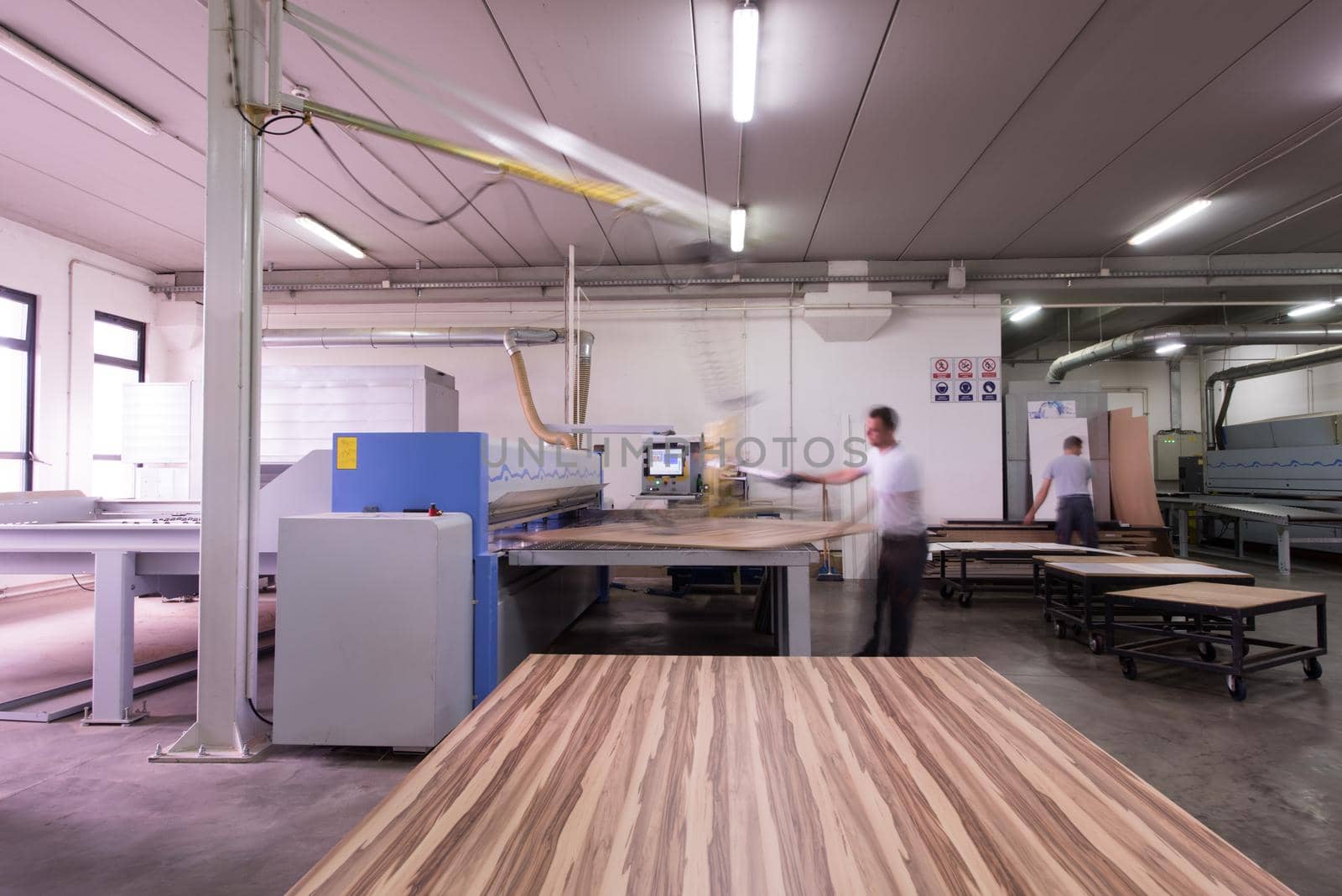 worker in a factory of wooden furniture by dotshock