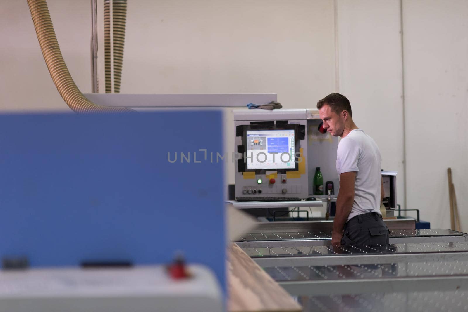 Young worker works in a factory for the production of wooden furniture