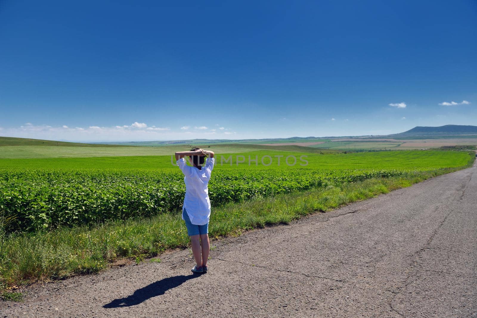 Young happy woman in green field by dotshock