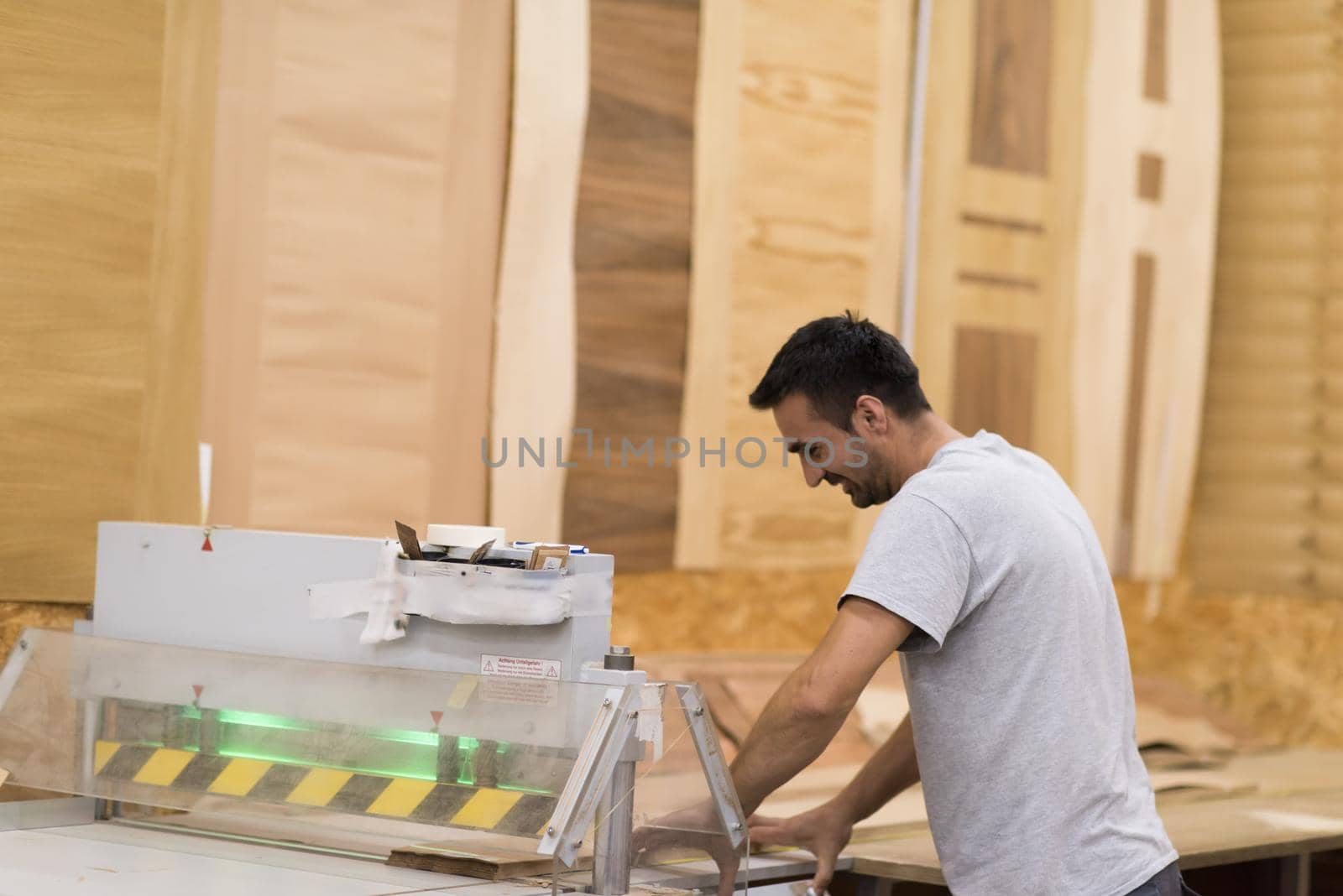 Young worker works in a factory for the production of wooden furniture