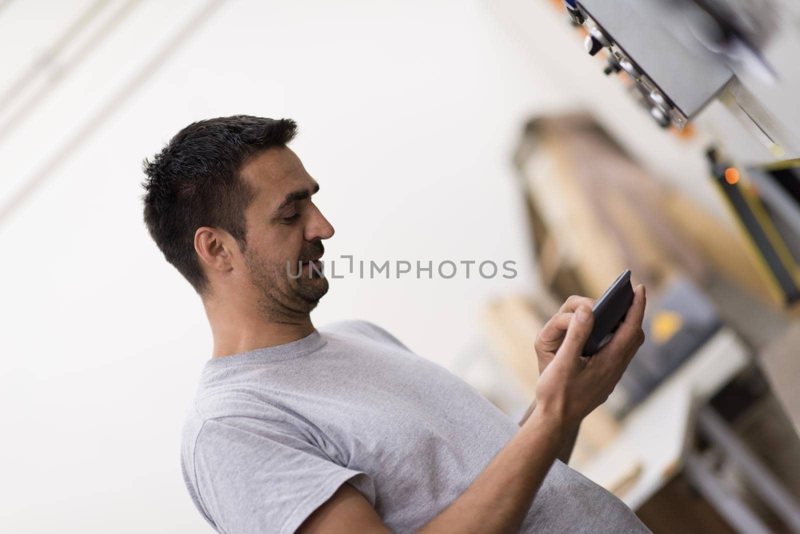 worker in a factory of wooden furniture by dotshock