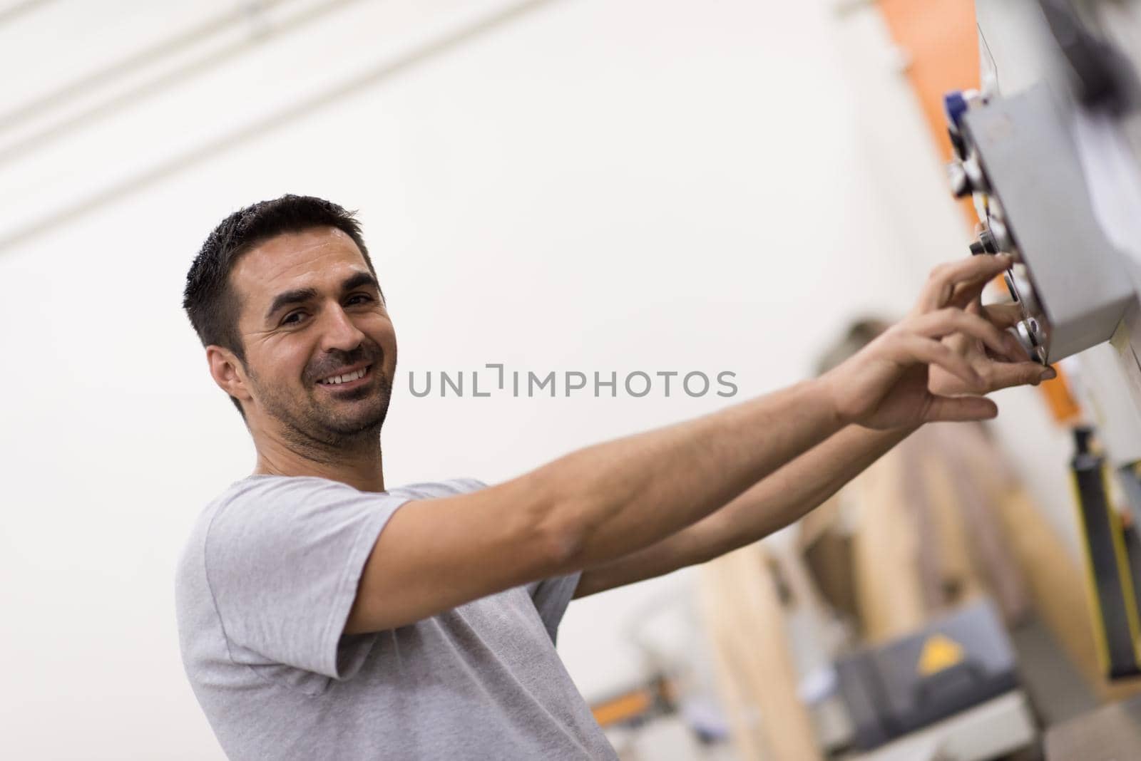 Young worker works in a factory for the production of wooden furniture