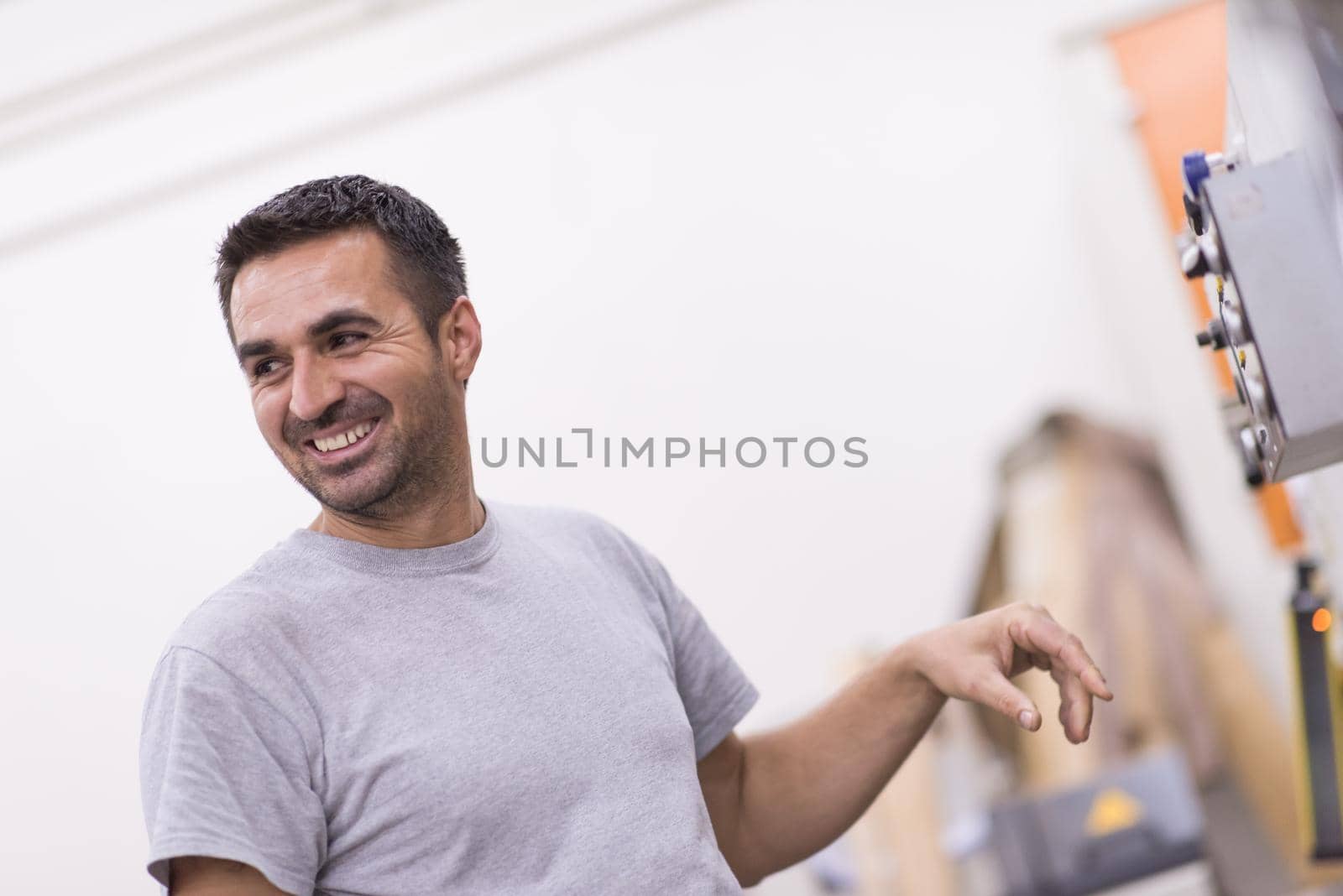 Young worker works in a factory for the production of wooden furniture