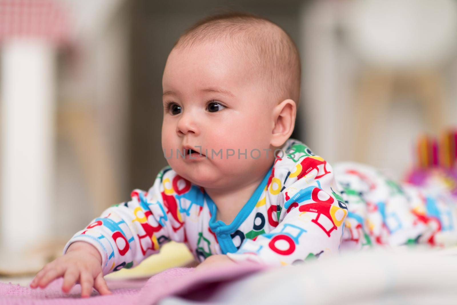 newborn baby boy playing on the floor by dotshock